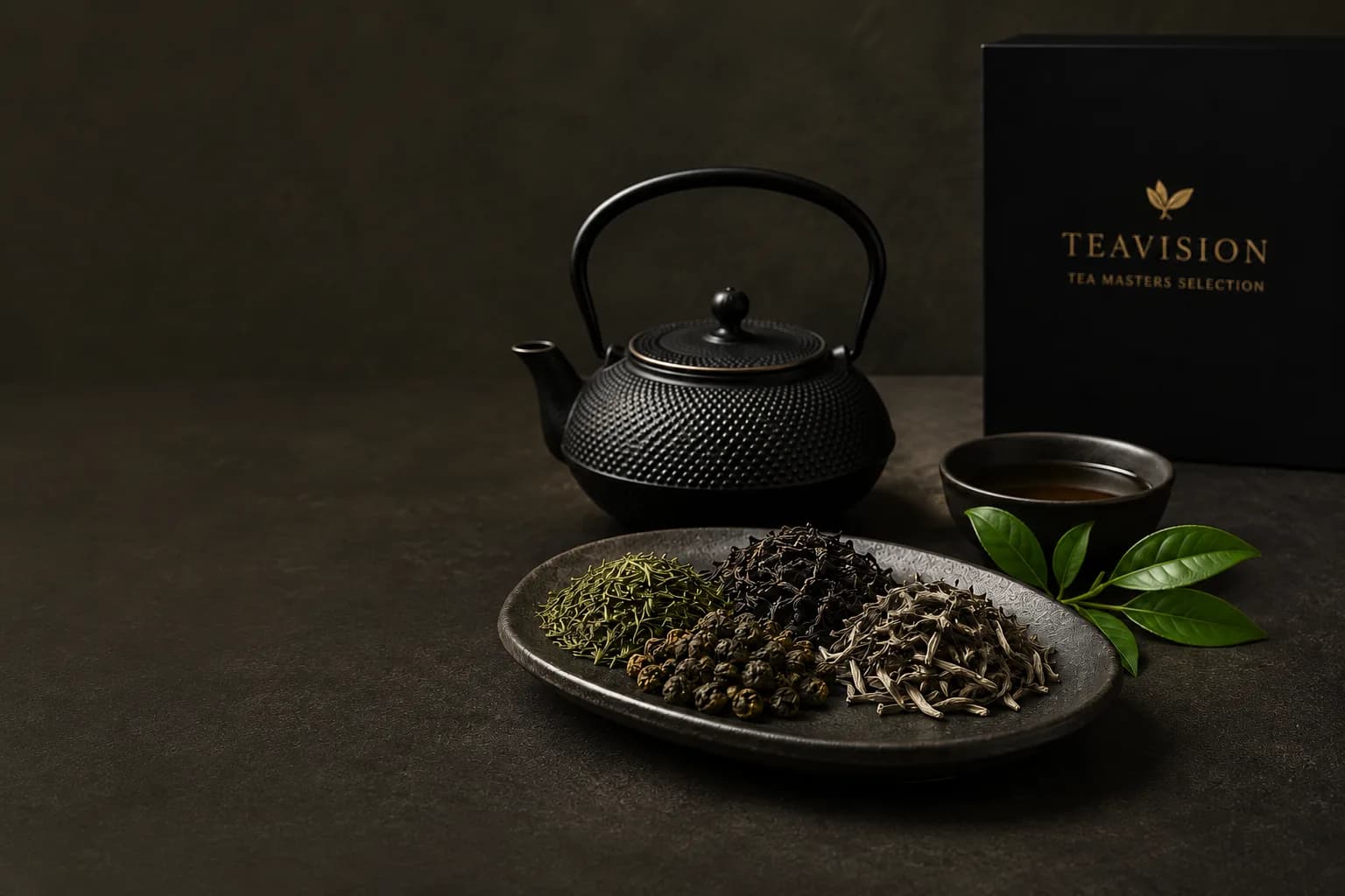 Black cast-iron teapot, Tea Masters Selection box and platter of loose teas