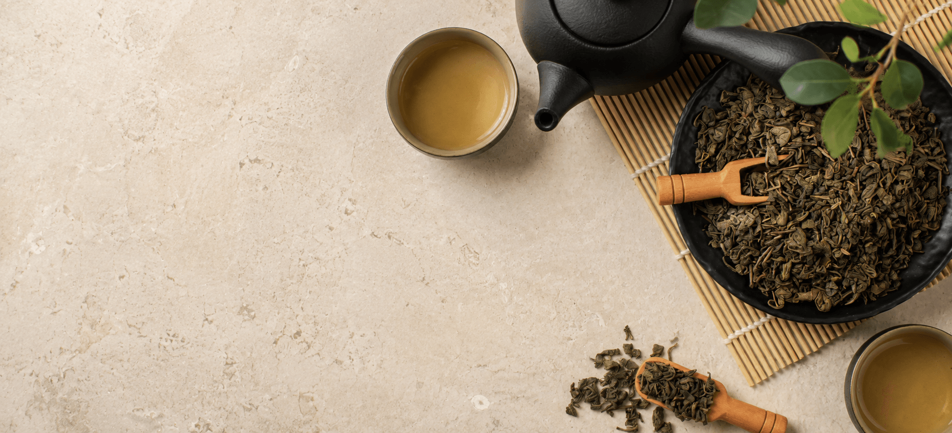 Loose-leaf green tea with a black teapot and cups